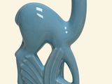 a blue statue of a deer that is sitting on a rock