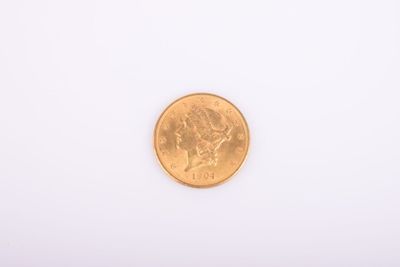 gros plan d'une pièce d'or sur une surface blanche