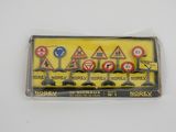 une boîte contenant des panneaux de signalisation miniatures posée sur une surface blanche