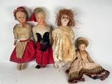 three antique dolls are posed in a row on a white background