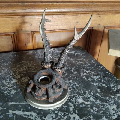 un bougeoir en métal orné d'une tête de cerf