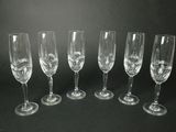six verres à vin vides alignés sur un fond noir