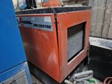 une machine posée sur le sol à côté d'un bâtiment