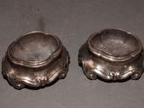 two silver bowls sitting on top of a table