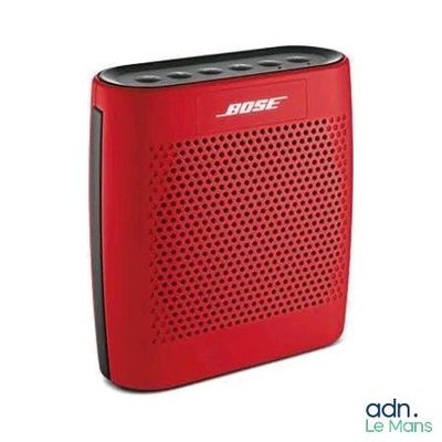 a red bose bluetooth speaker sitting on top of a white surface
