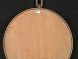 an image of a wooden pizza board hanging on a black background