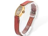 a close up of a wrist watch with a red strap