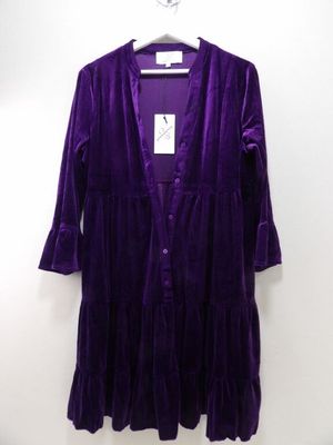 une robe violette suspendue à un cintre sur un mur blanc