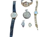 Plusieurs montres et bracelets sont disposés sur une surface blanche
