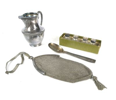 a silver pitcher, spoon, and other items on a white surface