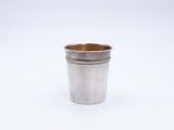 a silver shot glass with a wooden rim on a white background