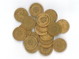 une pile de pièces d'or sur une surface blanche