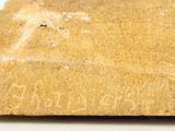 a rock with writing on it on a white surface