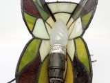 a lamp that is sitting on a table with a butterfly on it