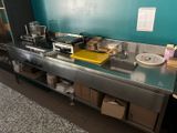 a kitchen with a stove, sink, microwave, and other items on the counter