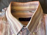 a close up of a striped shirt on a bed