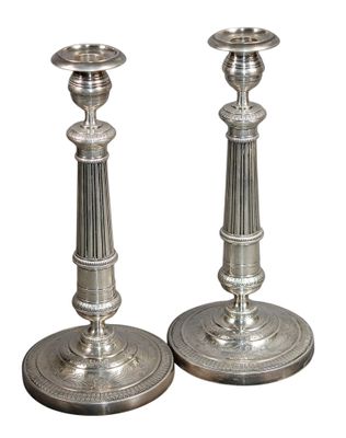 une paire de bougeoirs en argent sur fond blanc, avec un fond blanc
