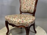 une image représentant une chaise dont l'assise est recouverte d'un tissu à motifs floraux, posée sur une table en marbre