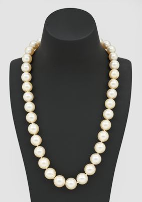 a white pearl necklace on a mannequin with a gold clasp