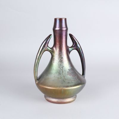 a metallic vase with a handle on a white background