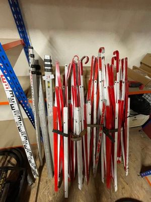 many skis and ski poles stacked on a shelf