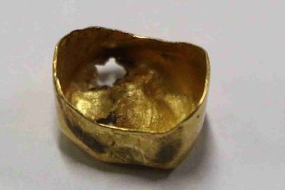 gros plan d'une bague en or sur une surface blanche