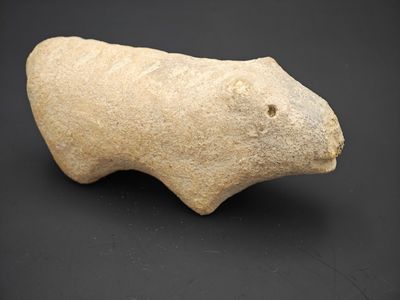 une image représentant une figurine d'animal en pierre posée sur une surface noire