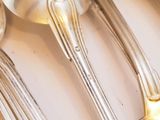 a lot of silver spoons and spoons on the table
