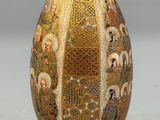 a gold vase with a picture of people on it