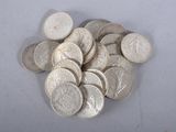 une pile de pièces d'argent posée sur une surface blanche