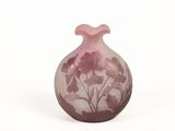 un vase orné d'un motif floral sur une surface blanche