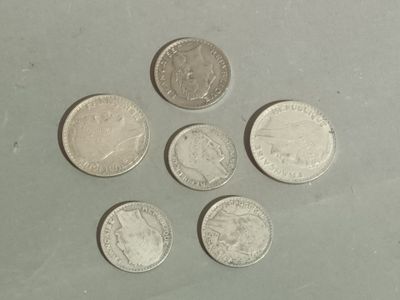six different coins are arranged in a circle on a table