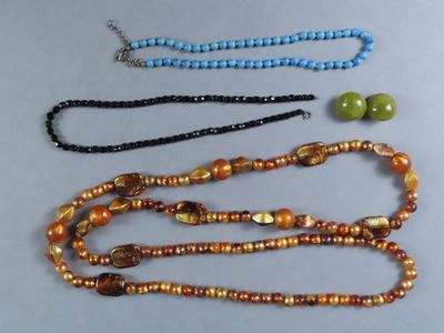 trois colliers de couleurs et de tailles différentes, ornés de perles