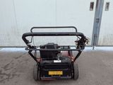 an image of a small lawn mower parked in front of a building