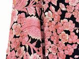 a close up of a black and pink dress with pink flowers on it