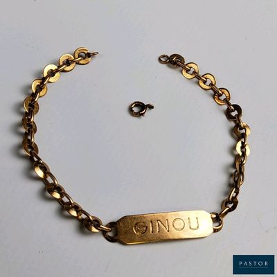 un gros plan d'un bracelet plaqué or sur lequel figure un prénom