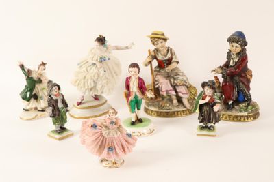 five figurines of people sitting on top of a table