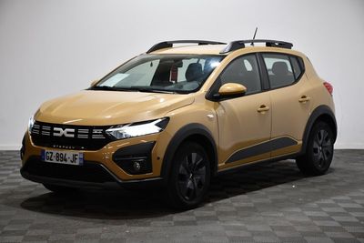 La voiture jaune est garée sur le sol à damier de la pièce.