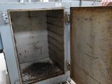a man standing next to an open oven in a building