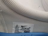 the back of a pair of white sneakers with a blue stripe