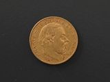 a close up of a gold coin on a black surface