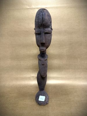 an old wooden statue of a man ' s head with a tag on it