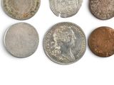 six different types of coins on a white surface
