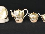 a group of silver and gold tea and coffee cups and saucers