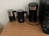 a small table with a coffee maker and cups on it