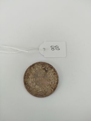a close up of a coin on a white surface with a tag