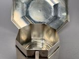an antique silver plate with a spoon in it on a table