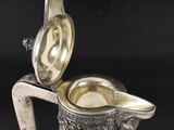 an antique silver plated glass pitcher with a silver lid