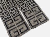 deux tapis noir et blanc posés sur une surface blanche, ornés d'un motif noir et blanc