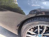 a close up of a car ' s tire with a reflection of a building in the background
